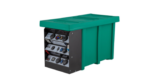Outdoor green enclosure with a metal front panel showing gauges, switches, and electrical components (a battery/storage cabinet).